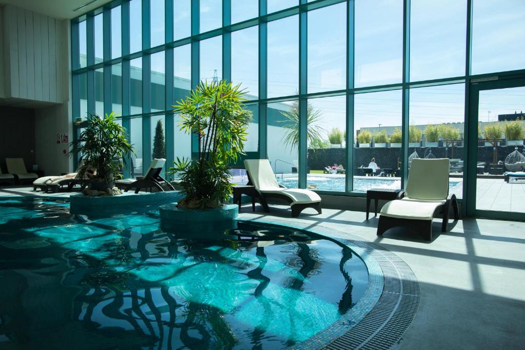 大莫尔文马尔文酒店的大堂内的大型游泳池,配有椅子和窗户