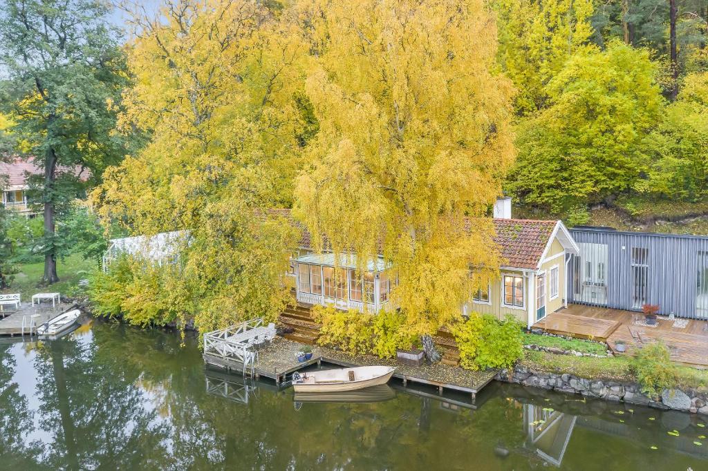 斯德哥尔摩Peaceful, Picturesque Lake & Forest Retreat的湖上的房子,水里有船