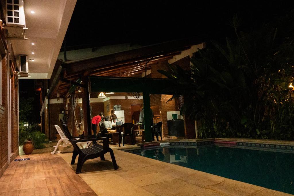 伊瓜苏港Managua Apart Hotel的一座晚上设有游泳池的房子