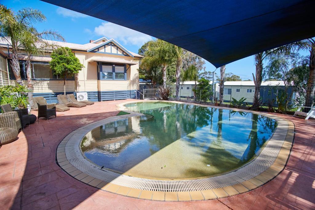 卡尔斯阿玛鲁公园酒店的一座带房子的庭院内的大型游泳池