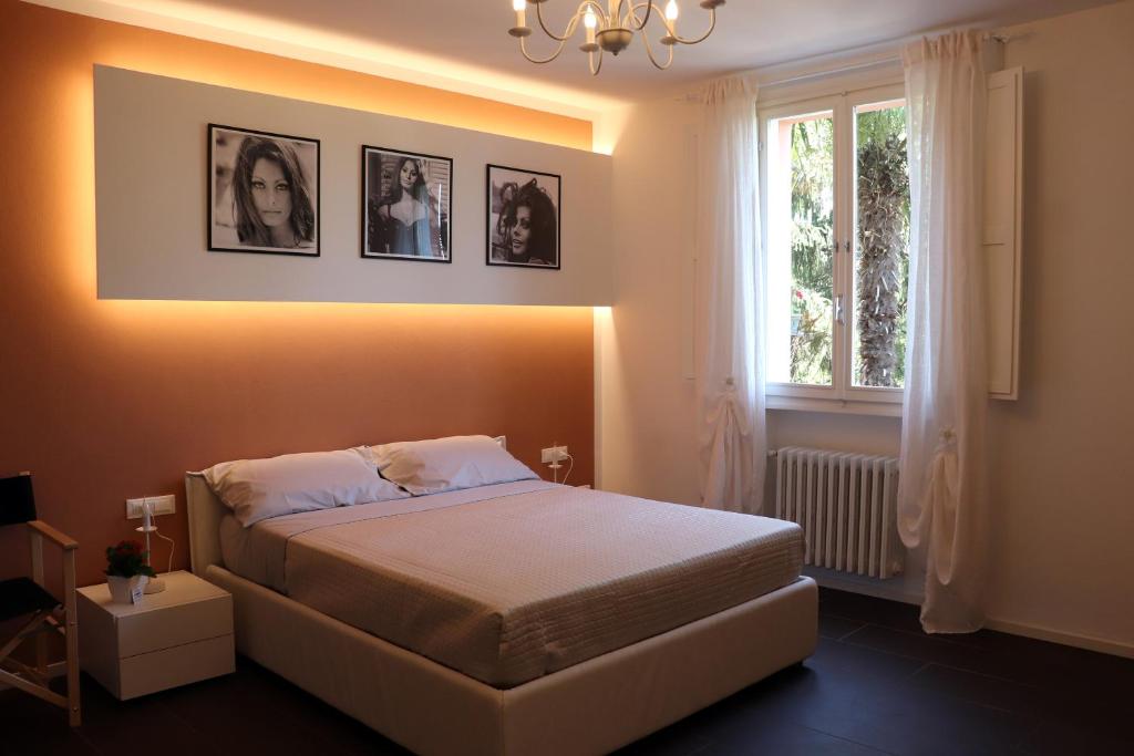 多扎Locanda Dolcevita的卧室配有一张墙上挂有照片的床