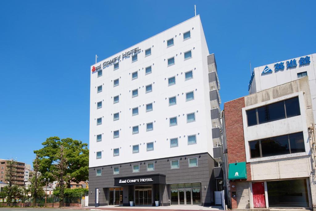 熊本&and COMFY HOTEL Kumamoto Jo View的街道拐角处的白色建筑