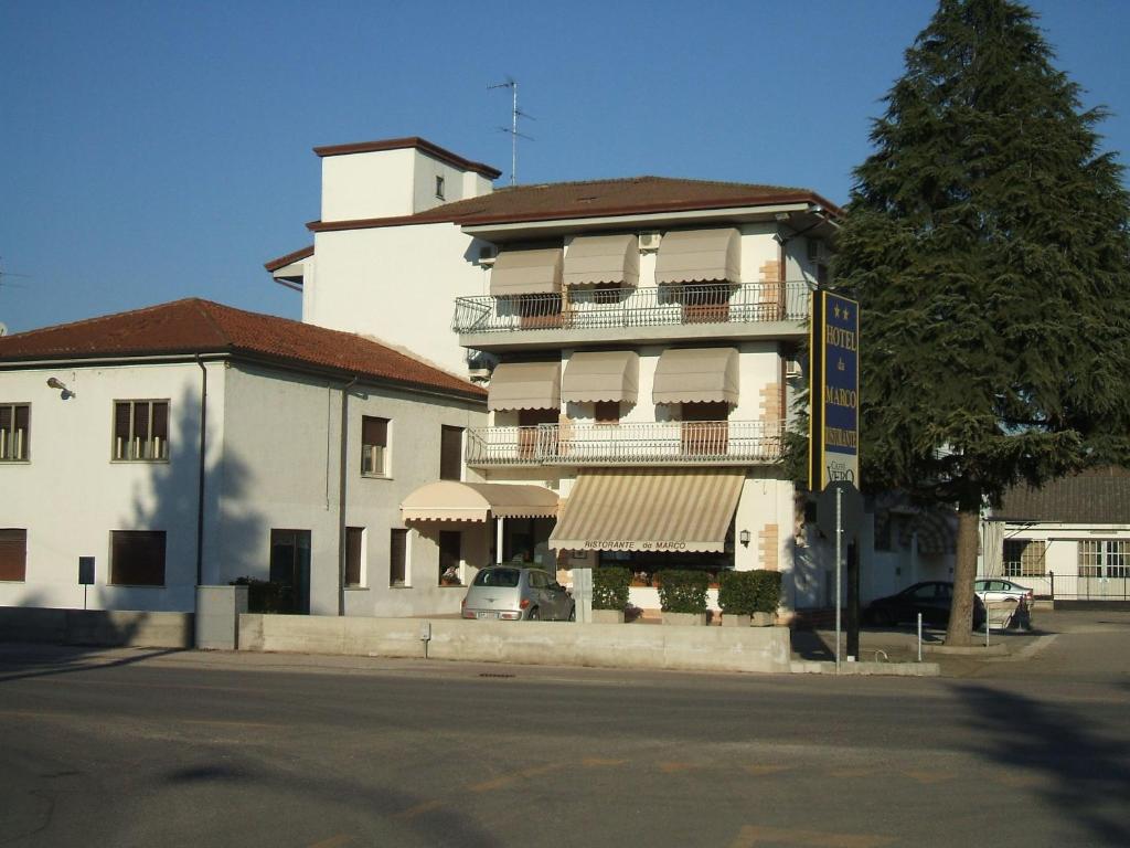 Bovolone达嘉尼餐厅酒店的街道上带阳台的大型白色建筑