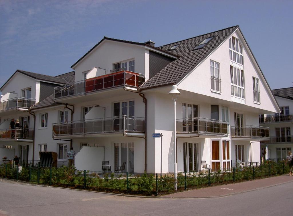 蒂索Ferienwohnung Ostseebrise的白色的公寓大楼,设有黑色屋顶