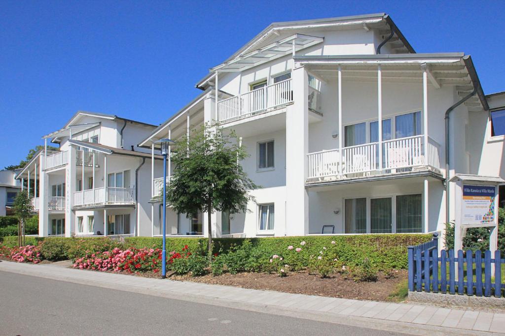奥斯特巴德·哥伦Balkon, gratis Nutzung vom AHOI Erlebnisbad und Sauna - Villa Karola FeWo 15的白色的公寓楼,位于街道上,设有阳台