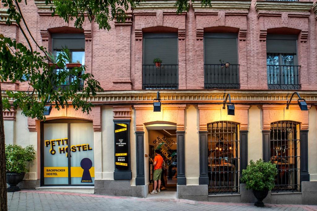 马德里Petit Hostel La Latina的砖楼前的商店,窗户上有人
