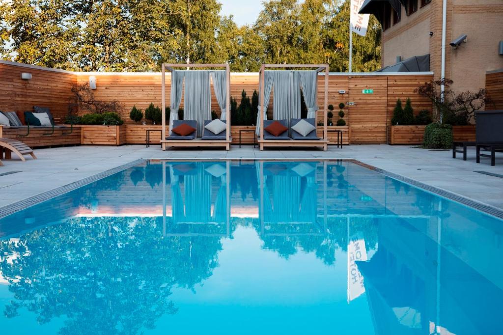 耶尔费拉巴尔卡欢迎酒店的木质围栏前带两把椅子的游泳池