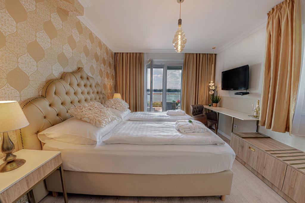 塔塔Casablanca Panzió的一间卧室配有一张大床和电视