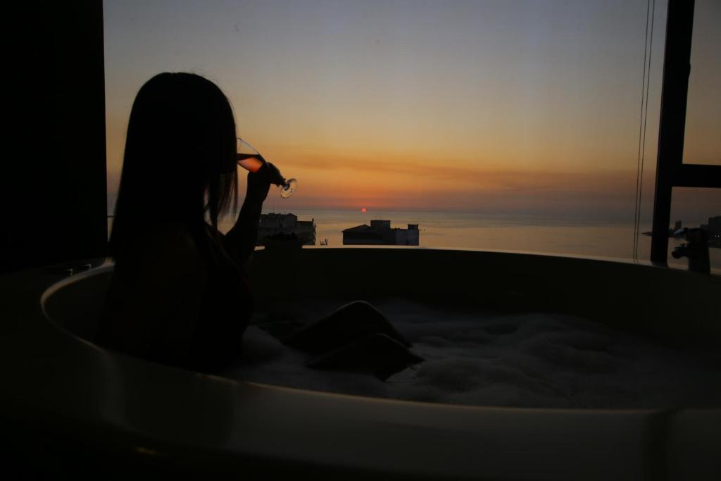 朱尼耶日出酒店的坐在浴缸里观看日落的女人