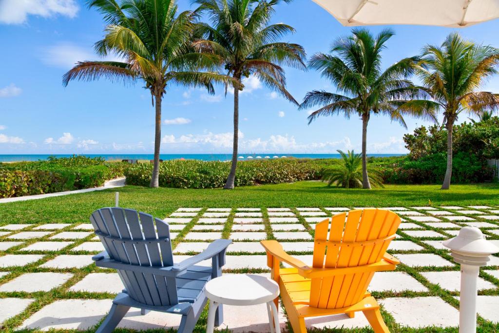 维洛海滩维洛海滩汽车旅馆的两把椅子坐在棕榈树庭院