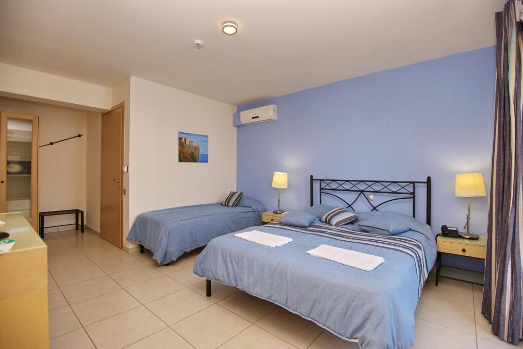 斯特尼瓦拉阿奥索斯4epoches的一间卧室配有两张带蓝色棉被的床