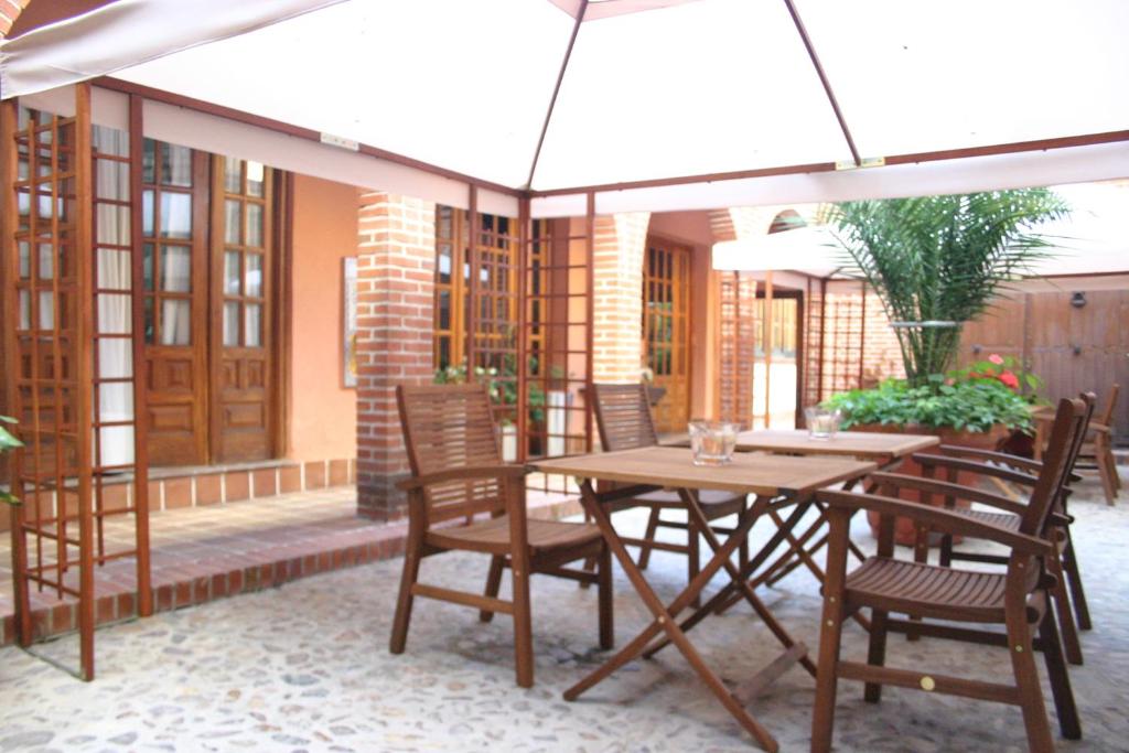 塔拉韦拉·德·拉·雷纳德拉格拉里雅可登宾馆的庭院内桌椅和遮阳伞