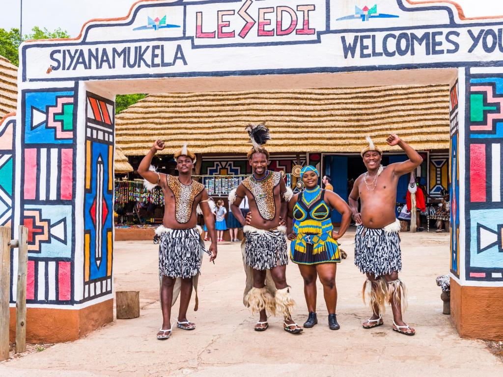 Pelindabaaha Lesedi African Lodge & Cultural Village的一群人,在大门前带着狗