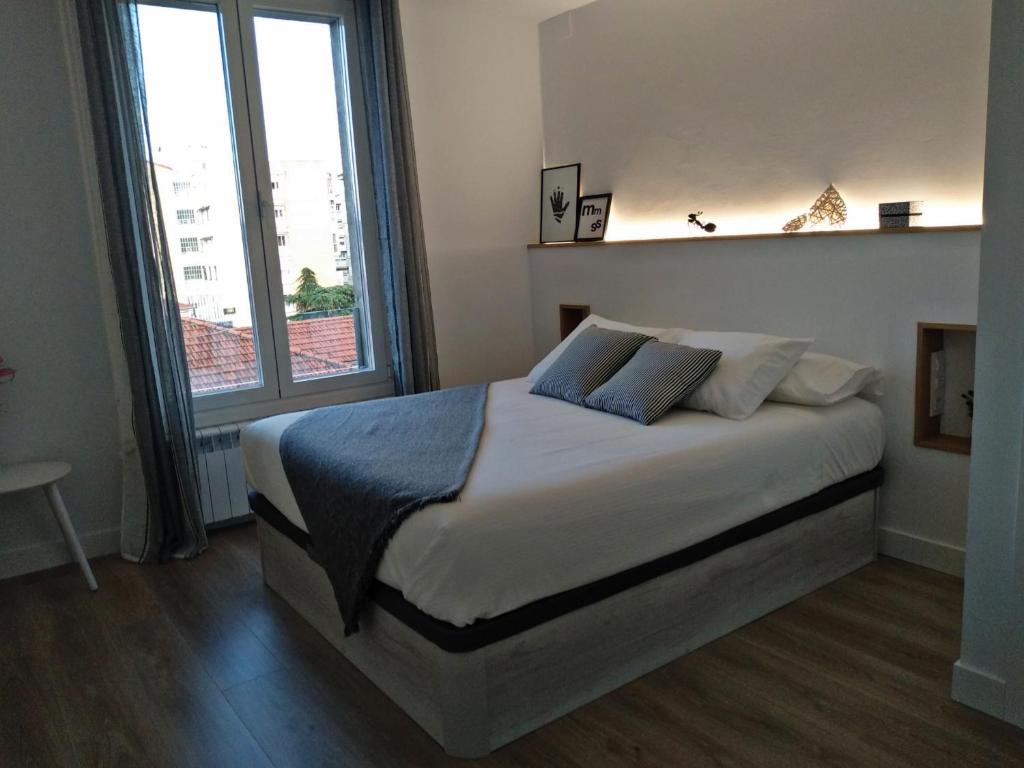 奥伦塞Morriña的一间卧室设有一张大床和一个大窗户