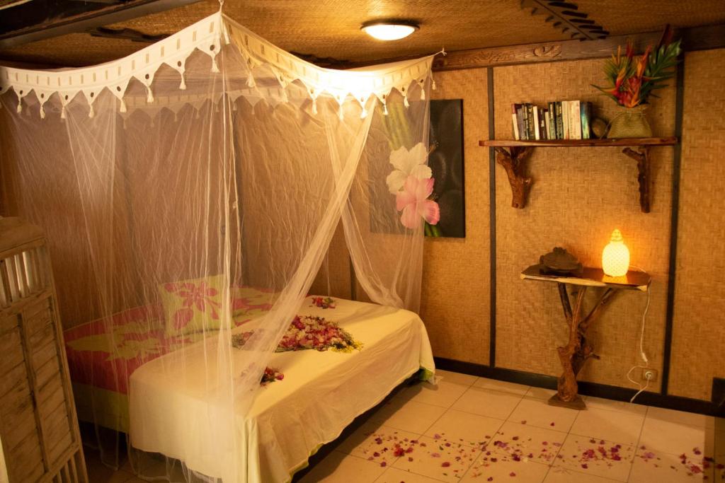 TeavaroHaere Mai I Te Fare的一间卧室配有一张带天蓬的床