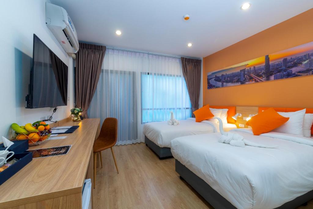 班敦孟7 Days Premium Hotel Don Meaung Airport的酒店客房配有两张床和一张书桌