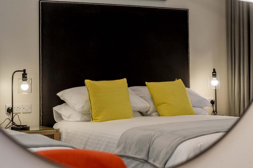 伦敦德里The James Suites的一间卧室配有一张带黄色枕头的床