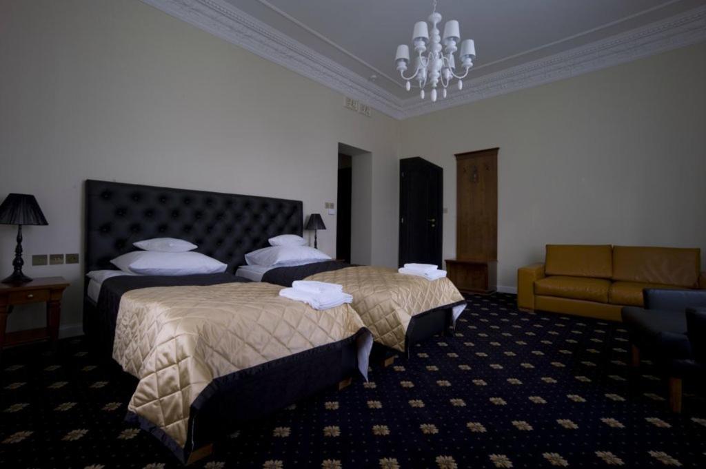 ZabużeDwór w Zabużu的酒店客房,设有两张床和一张沙发