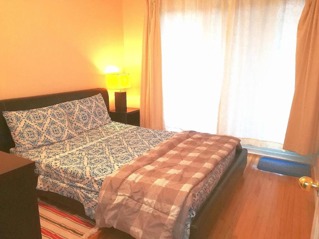 蒙特利尔Montreal Authentic appartment的一间卧室配有一张带枕头和窗户的床