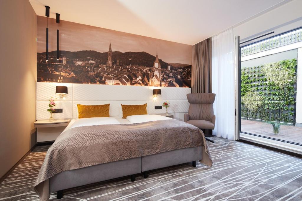弗莱堡Boutiquehotel am Stadtgarten的一间卧室设有一张大床和一个大窗户