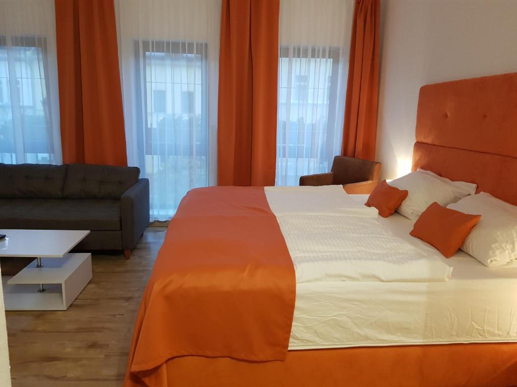 赖兴巴伊姆福格特兰Hotel Milin的一间卧室配有一张大床和一张沙发