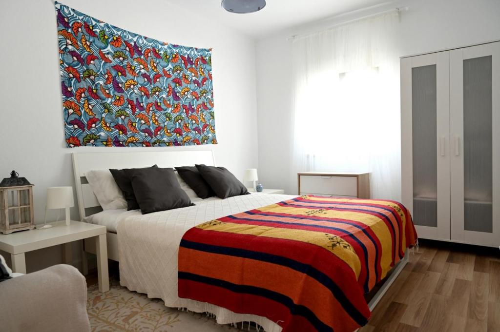 萨尔堡Casa dos Clérigos的一间卧室配有一张大床和色彩缤纷的毯子