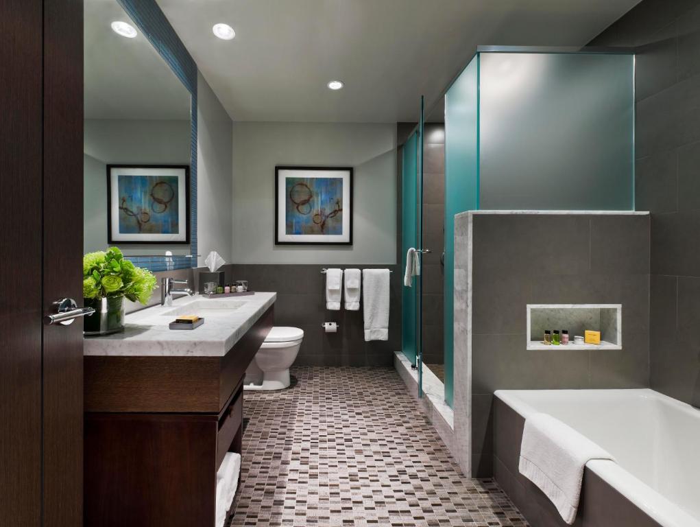 纽约珍珠酒店的一间带两个盥洗盆、浴缸和卫生间的浴室