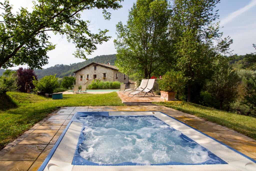 CollazzoneCASALE SANTA CATERINA Jacuzzi and Pool的庭院中间的游泳池,有房子