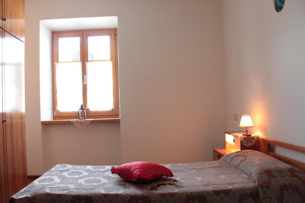 TassulloAgritur Odorizzi的一间卧室配有一张红色枕头的床