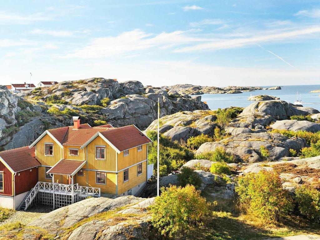 谢尔港12 person holiday home in Sk rhamn的一座位于岩石山丘上的海洋度假屋