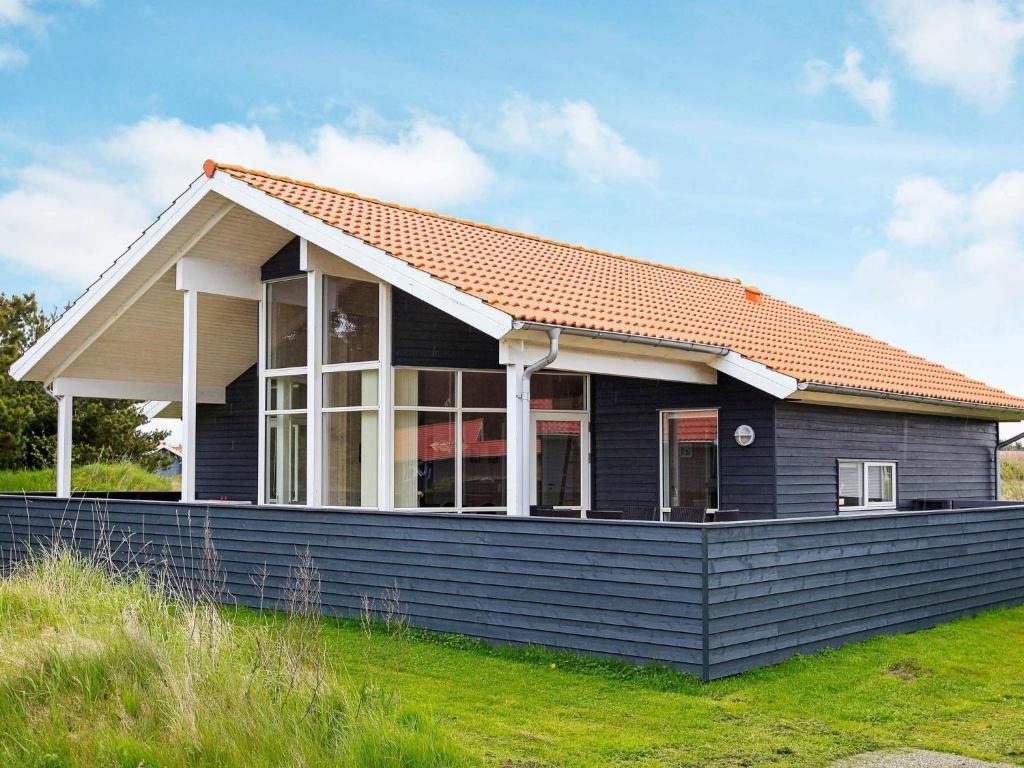 法贾德嘉德Three-Bedroom Holiday home in Ulfborg 23的蓝色房子,有橙色屋顶