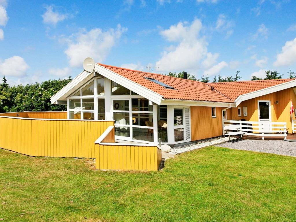 瓦伊厄斯斯特兰德8 person holiday home in Vejers Strand的院子中带橙色围栏的房子