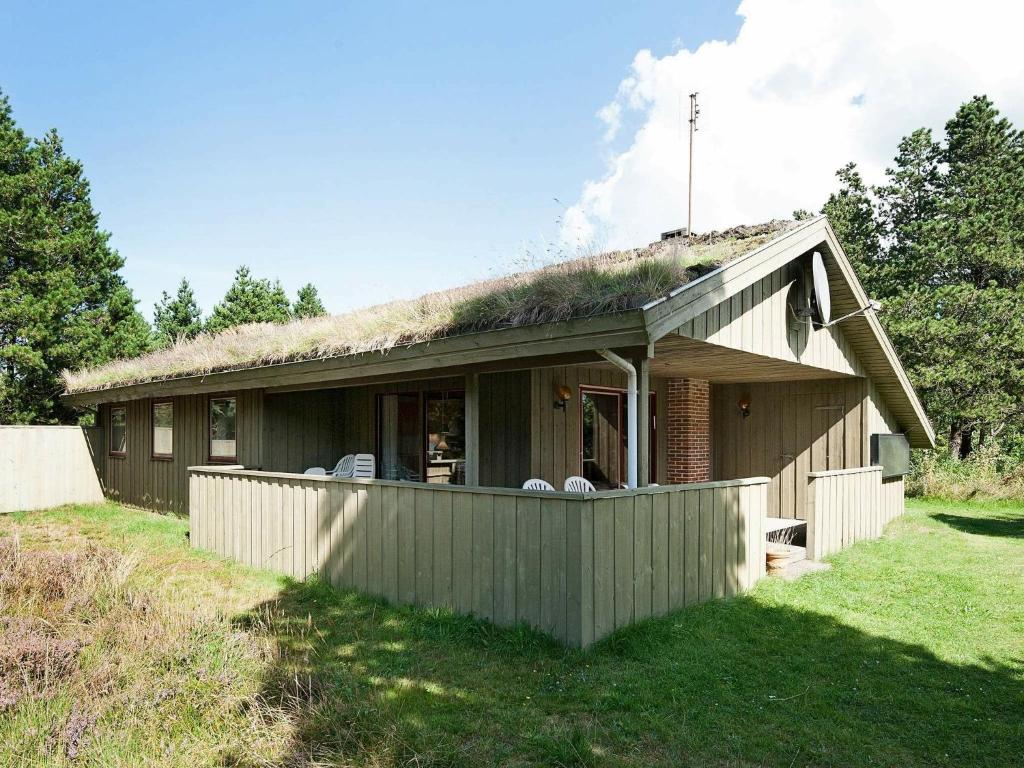 博利尔马克6 person holiday home in R m的草屋顶的小房子