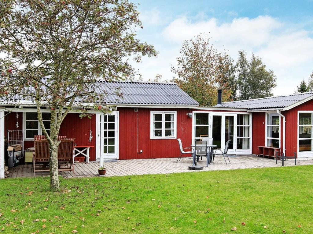 Store Fuglede6 person holiday home in Store Fuglede的红色的房子,设有庭院和庭院