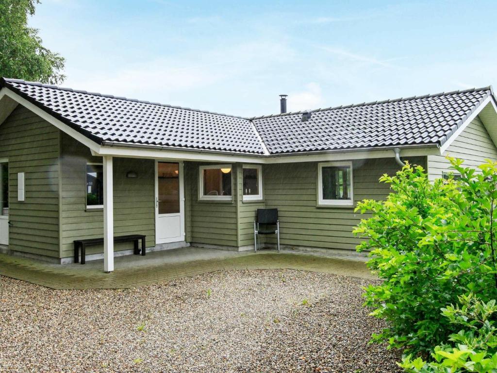 安斯艾厄Holiday Home Søgårdsvej IV的前面有长凳的绿色房子