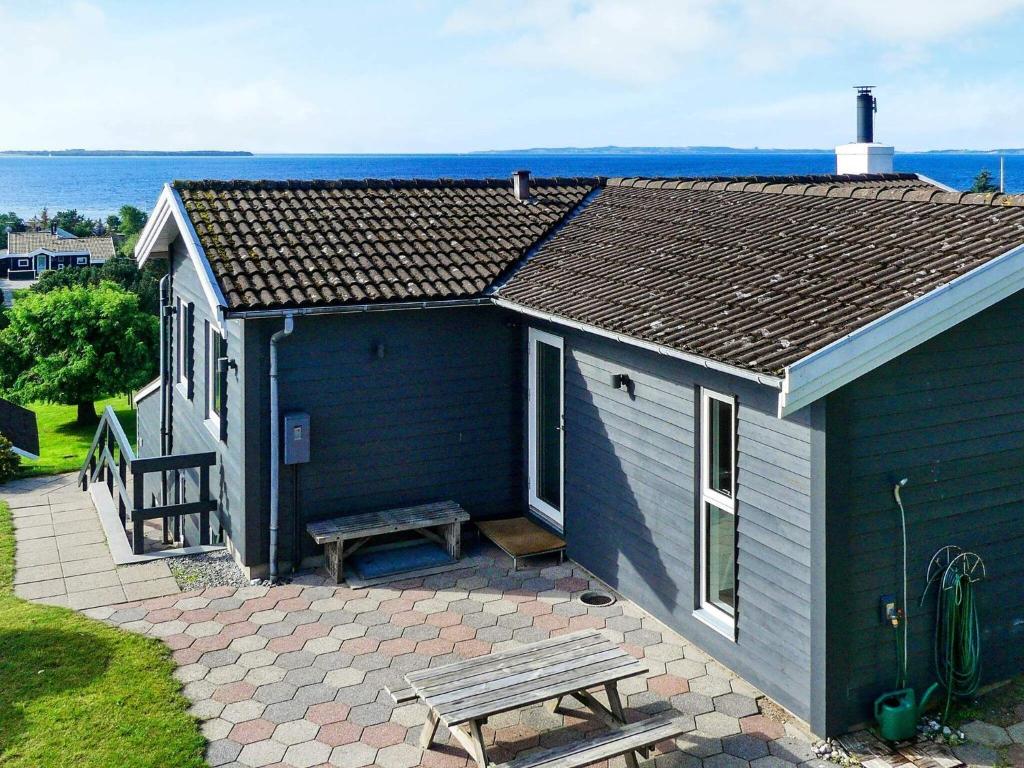 埃贝尔托夫特8 person holiday home in Ebeltoft的蓝色的房子,配有野餐桌和长凳