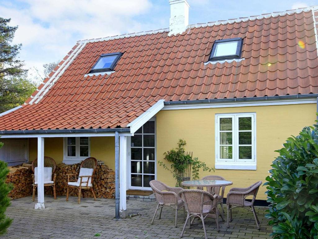 斯卡恩4 person holiday home in Skagen的黄色的房子,配有桌子和椅子
