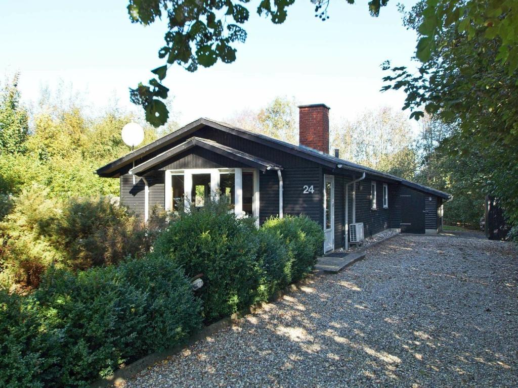 海默特6 person holiday home in Hemmet的一座黑色的小房子,上面有砖烟 ⁇ 