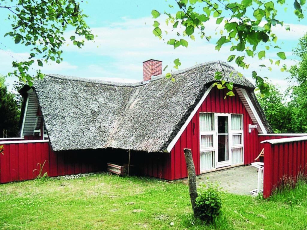 朗尼赫德Three-Bedroom Holiday home in Nørre Nebel 16的灰色屋顶的红色房子