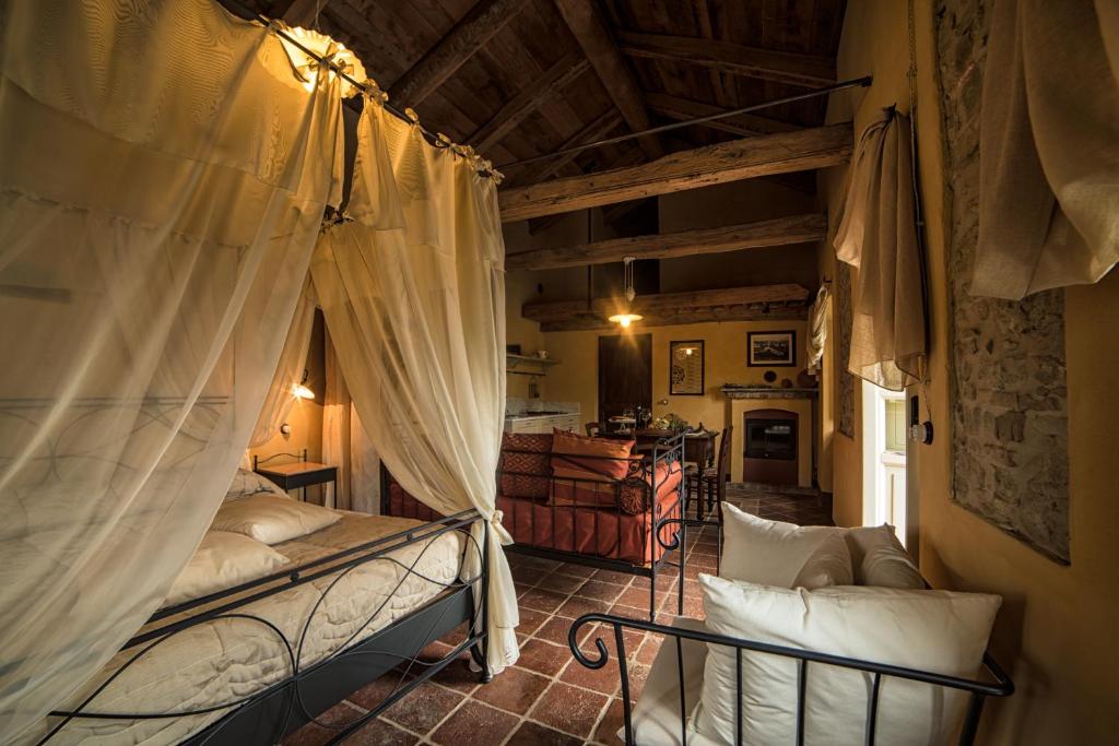 Cerretto Langhe迪莫拉斯托里科罗曼迪卡伊尔索莱伊娜卢纳乡村民宿的一间卧室,卧室内配有床帘