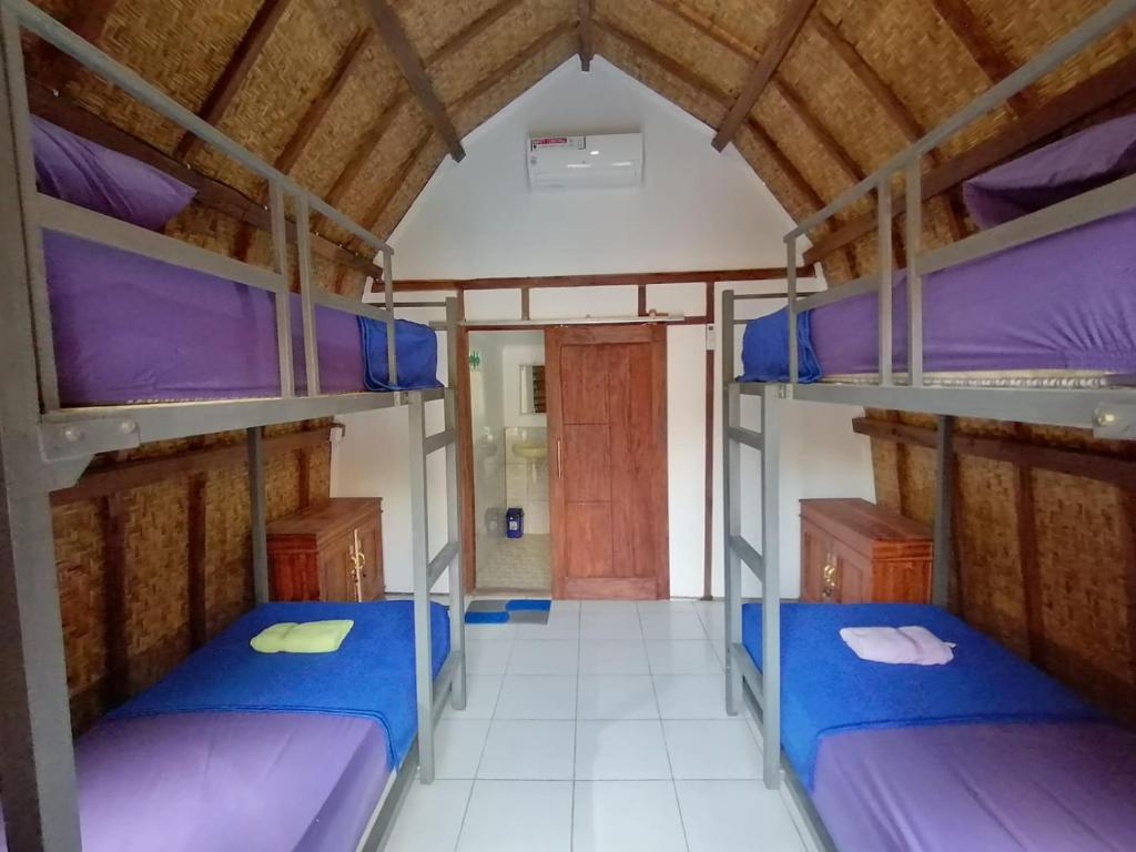 龙目岛库塔Bale Hostel的宿舍间设有三张双层床。
