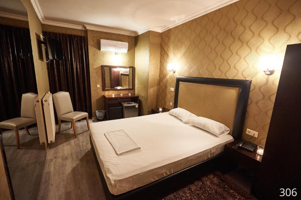 雅典大西洋酒店 的一间卧室配有一张床和一把椅子