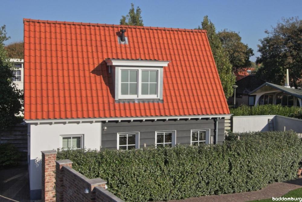 栋堡Zuidstraat 3a - baddomburg的一座带树 ⁇ 的房子上的橙色屋顶