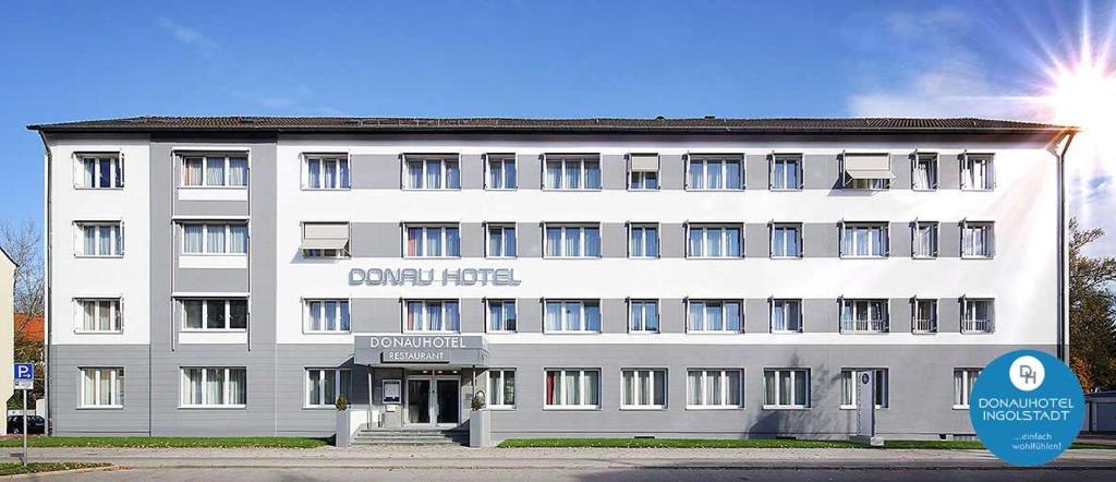 因戈尔施塔特DONAUHOTEL Ingolstadt的前面有标志的大型白色建筑