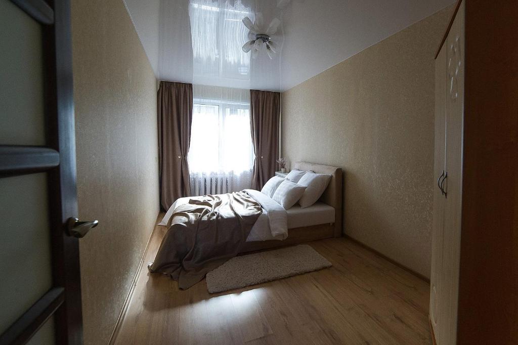 索利戈尔斯克PaulMarie Apartments on Molodeznaya的卧室配有带白色枕头的床和窗户。