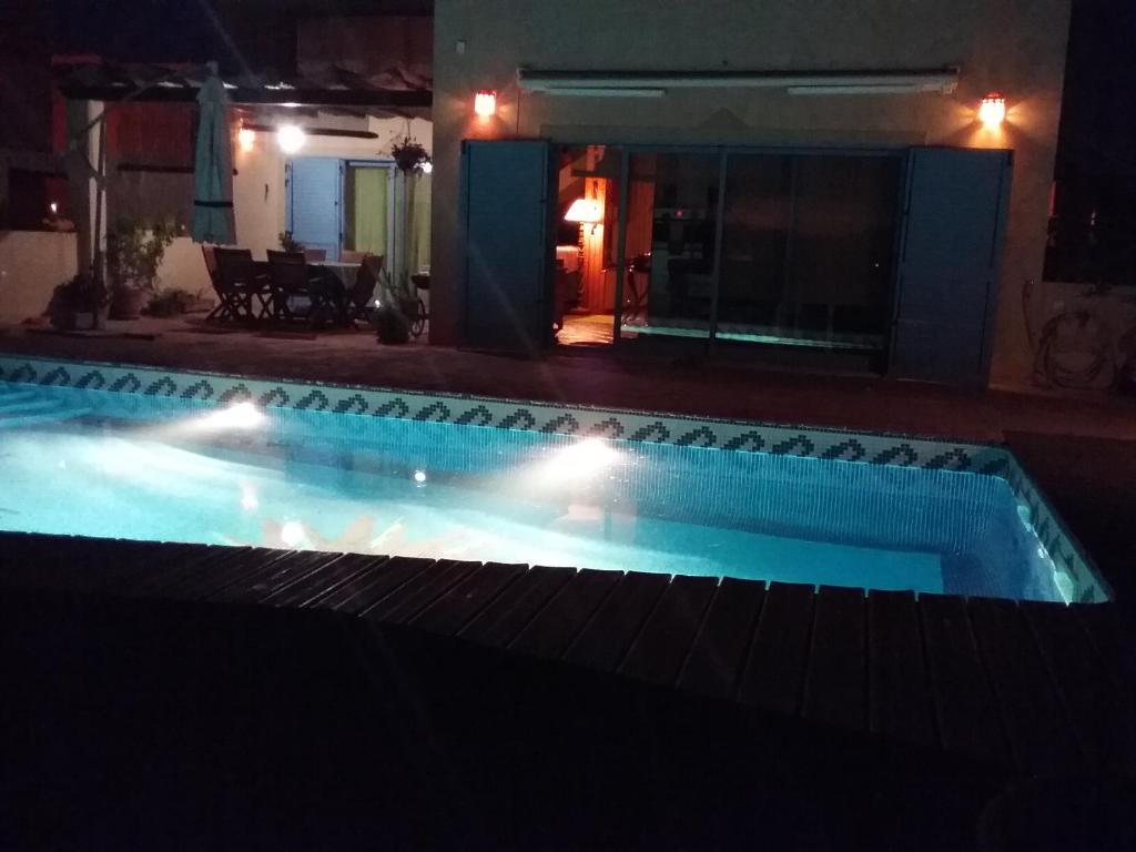 曼塔罗塔Manta Rota Beach, Bed & Breakfast in a villa,privat pool的游泳池在晚上点亮,灯光照亮