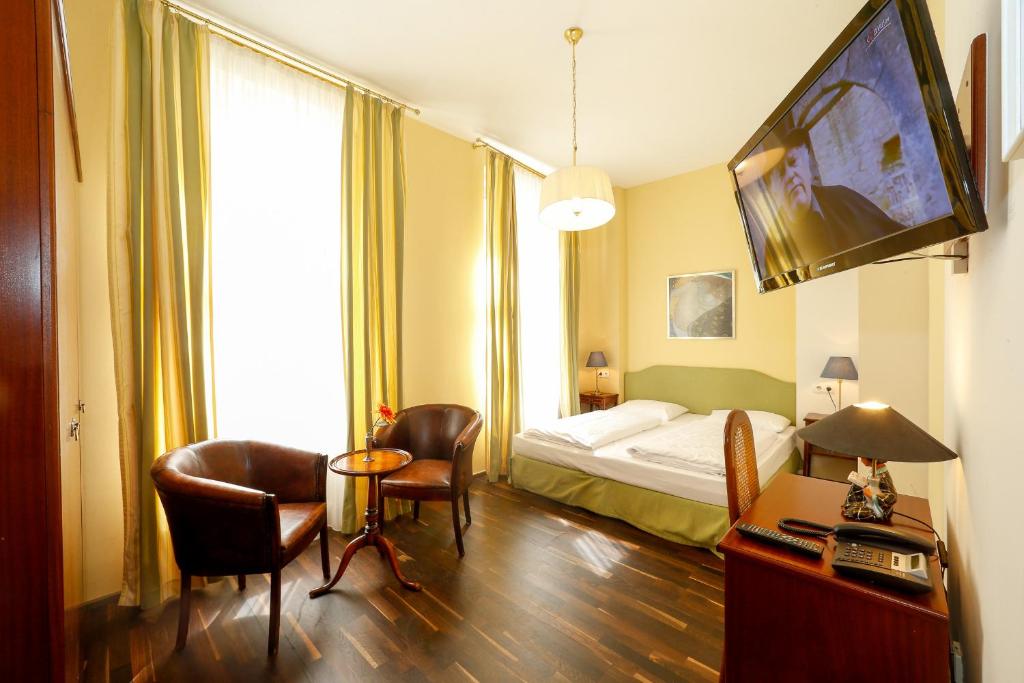维也纳Self Check-in Time Out City Hotel Vienna的酒店客房带一张床、一张桌子和椅子