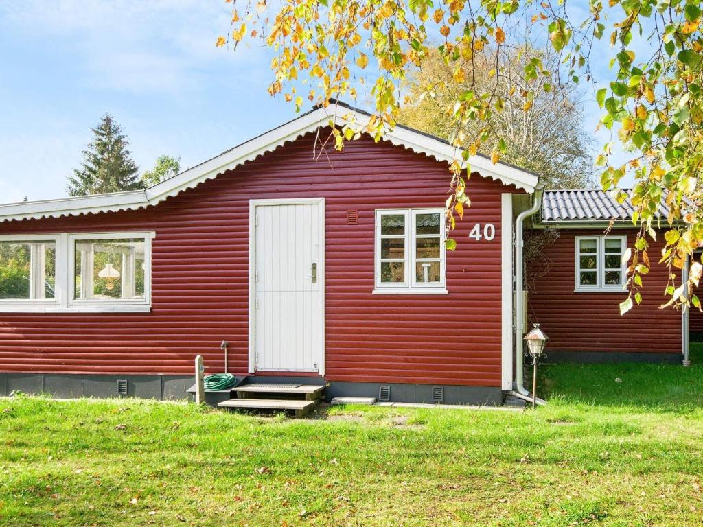 格莱斯堡4 person holiday home in Glesborg的红色的房子,有白色门
