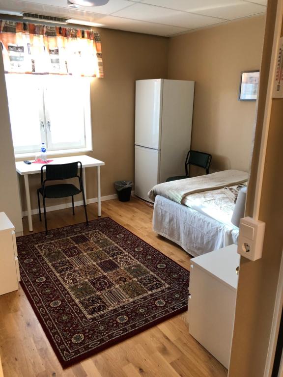 耶尔费拉Golden Hostel的一间卧室配有一张床、一张书桌和一台冰箱