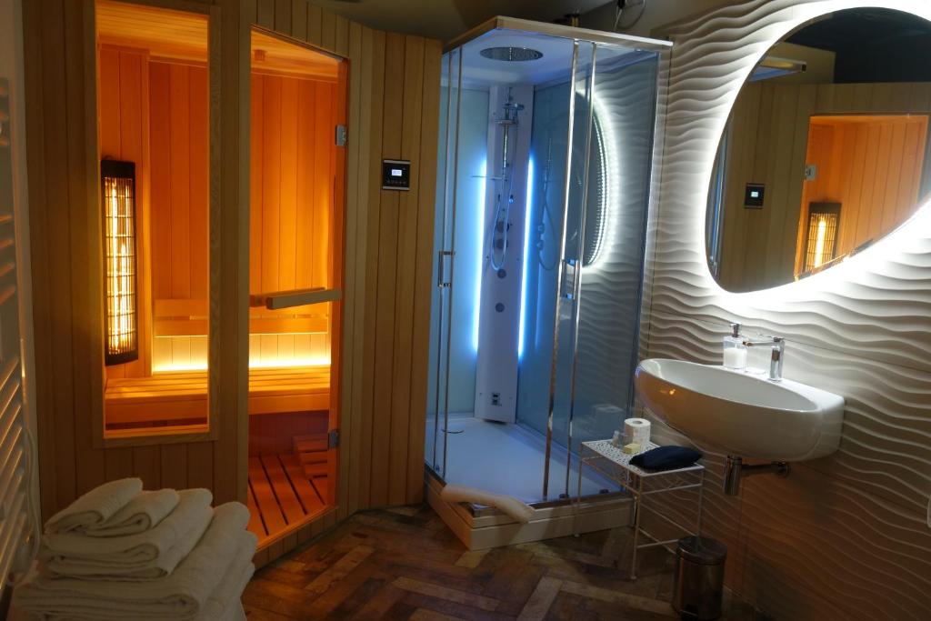 内米Holiday Homes - mini spa - Nemi (Roma)的浴室配有盥洗盆和带镜子的淋浴